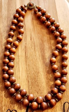 2 strand vintage necklace with wood beads and an ornate clasp. Elegant Multi-strand Necklaces With Wooden Beads, Elegant Multi-strand Necklace With Wooden Beads, Adjustable Double Strand Necklaces With Wooden Beads, Adjustable Double Strand Necklace With Wooden Beads, Natural Wood Jewelry With 8mm Beads, Adjustable Multi-strand Wooden Beads Necklaces, Adjustable Brown Wooden Necklaces, Vintage Multi-strand Wooden Beads Jewelry, Traditional Multi-strand Wooden Bead Necklaces