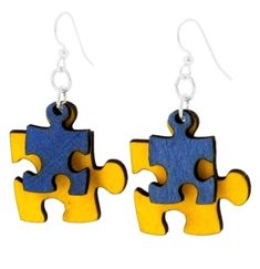 two pieces of the same puzzle are being held together by silver earwires on white background