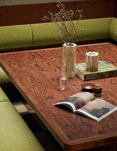 a wooden table topped with books and vases filled with flowers on top of it