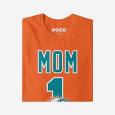 She’s not just your mom, she’s the best one around! A mom as amazing as yours deserves a shirt that shows off her favorite team. Make sure everyone knows how great of a mom and fan she is with this Miami Dolphins #1 Mom T-Shirt. This top features a design that showcases your all-important team colors and a bold team logo display across the chest, meaning this t-shirt will prove your unmatched dedication to the Miami Dolphins when you’re at the game or watching at home with your #1 family. In oth One Piece Pajamas, Team T Shirts, Team Shirts, Miami Dolphins, Your Mom, Everyone Knows, Everyday Wardrobe, Lounge Pants, Number 1