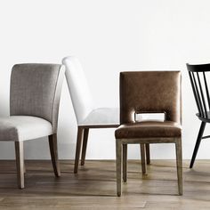 four different chairs are lined up in a row, one is white and the other is brown