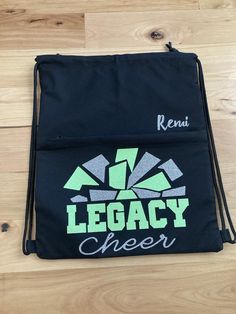 a black drawsack bag with the words legacy cheer printed on it