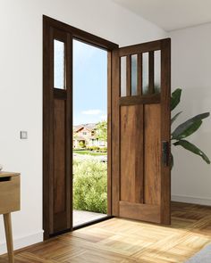 an open wooden door in a white room next to a table with a potted plant