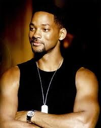 a man standing with his arms crossed in front of him, wearing a black tank top