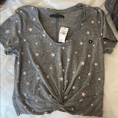 Grey With White Stars T-Shirt With Knotted Middle Casual T-shirt With Star Print For Spring, Spring Graphic Tee With Star Print, Casual V-neck Star Print Top, Casual Star Print Tops For Loungewear, Casual Short Sleeve Top With Star Print, Summer Star Print Top For Loungewear, Casual Star Print V-neck Top, Star Tshirt, Star T Shirt