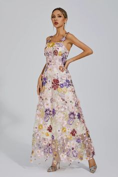 a woman in a floral dress posing for the camera