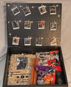 an open suitcase with pictures and candies on the string strung from it's lid