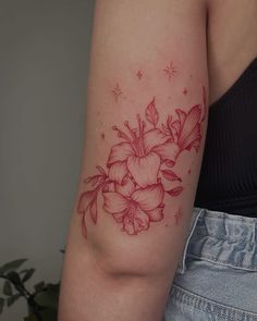 a woman's arm with a red flower tattoo on the left side of her arm