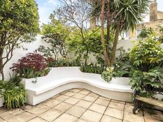 a white bench sitting in the middle of a garden