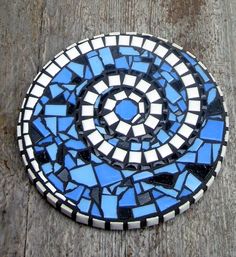 a blue and white mosaic design on a wooden surface