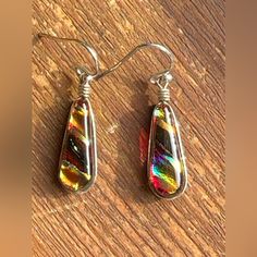 a pair of earrings sitting on top of a wooden table