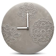 a clock made out of cement with lace on it