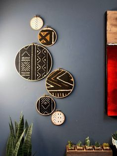 the wall is decorated with different types of decorative plates on it, along with succulents and cacti