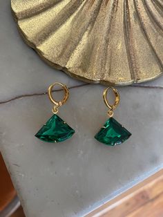 Vintage emerald green glass stone set in a raw brass setting measuring 1.8 cm x 1.3 cm. Hung on gold-plated huggie hoop earrings measuring 1.2 cm x 1.4 cm. Comes in a black velvet pouch. If these are a gift and you would like a box free of charge please mark the order as gift or leave a message at check out. Green Gemstone Small Hoop Jewelry, Small Hoop Green Earrings For May Birthstone, Green Tarnish-resistant Huggie Jewelry, Green Huggie Earrings With Matching Set, Green Small Hoop Huggie Earrings For May Birthstone, Green Tarnish-resistant Hoop Jewelry, Green Brass Jewelry For Party, Green Hoop Earrings For May Birthstone, Green Huggie Earrings For May Birthstone