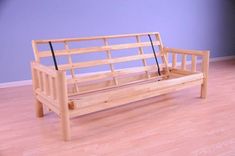 a wooden bench sitting on top of a hard wood floor next to a blue wall