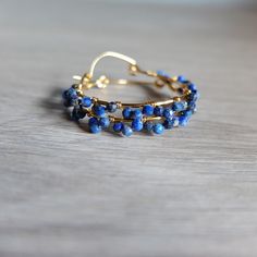 These beautiful fine  hoop earrings have beautiful faceted blue Lapis Lazuli  and gold filled wire .  The gemstones are  deep  blue   color with natural calcite stripes  The genuine  beads are wire wrapped around gold filled  hoops in small clusters The gemstones are faceted genuine lapis lazuli and they are completely handwrapped by me with gold filled wire   Diameter of the hoops is  3,00  cm- total diameter is 3.50 cm The round shaped, faceted stones measure  3 mm approximately    please note Bohemian Blue Wire Wrapped Hoop Earrings, Blue Small Hoop Earrings Wire Wrapped, Blue Small Hoop Earrings With Wire Wrapping, Blue Small Hoop Wire Wrapped Earrings, Blue Wire Wrapped Small Hoop Earrings, Blue Wire Wrapped Hoop Earrings As Gift, Blue Wire Wrapped Hoop Earrings For Gift, Small Blue Wire Wrapped Hoop Earrings, Blue 14k Gold-filled Wire Wrapped Jewelry