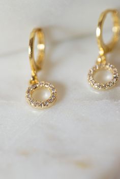 Our Myla Dainty O-Ring Huggie Earrings are the perfect minimalist earrings! Made with a crystal beaded gold filled O-Ring attached to a gold filled huggie hoop. These simple earrings are a beautiful staple piece! Gold Plated Hoop Earrings With Sparkling Stones, Gold Hoop Earrings With Halo Detail As Gift, Gold Cubic Zirconia Hoop Earrings With Halo, Gold Halo Hoop Earrings As A Gift, Everyday Gold Cubic Zirconia Earrings, Gold Huggie Earrings With Halo For Gift, Gold Dainty Hoop Earrings With Sparkling Stones, Gold Hoop Jewelry With Sparkling Stones, Dainty Gold Hoop Earrings With Sparkling Stones