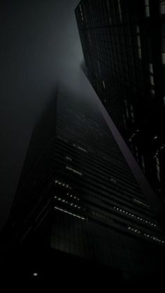 a very tall building in the foggy night