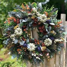 a wreath is hanging on a wooden fence