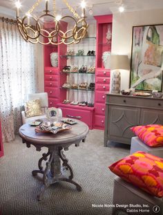 a living room filled with furniture and a chandelier hanging from the ceiling over a table