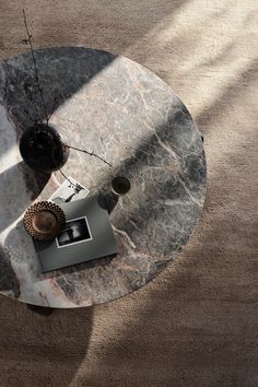 a marble coffee table with two vases on it and a lamp in the middle