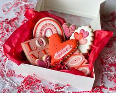 a box filled with lots of decorated cookies