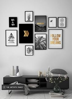 a black and white living room with pictures on the wall, bookshelf and vase