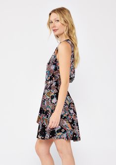 A sleeveless belted mini dress in a black and mixed floral print. Mixed floral print Relaxed fit Sleeveless Mini length Button-front Ruffle-trimmed tiered skirt V-neckline Adjustable attached d-ring belt Smocked elastic waist Fall mini dress A versatile sleeveless mini dress that will take you from day to night with ease. Designed in a classic mixed floral print, with a ruffle-trimmed tiered skirt, a v-neckline, and a smocked elastic waist for added definition. Elevated with a charming d-ring be Black Bohemian Sleeveless Dress With Floral Print, Black Floral Print Sundress Sleeveless, Black Floral Print Sleeveless Sundress, Multicolor Sleeveless Ditsy Floral Dress, Sleeveless Floral Print Patterned Mini Dress, Patterned Floral Print Sleeveless Mini Dress, Black Sleeveless Dress With Ditsy Floral Print, Sleeveless Paisley Print Mini Dress For Vacation, Sleeveless Mini Dress With Paisley Print For Summer