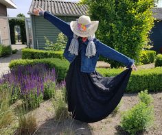 a woman in a long black dress and cowboy hat with her arms out, standing outside