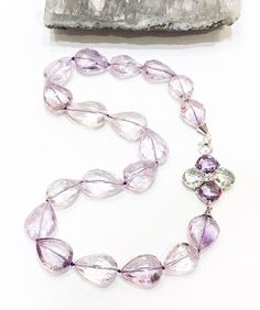 Stunning quality lilac Amethyst stones, faceted and shaped like teardrops, finished with a large 925 silver clasp set with faceted green amethyst and lilac amethyst stones arranged as a flower.Measuring approximately 22" in length. All jewellery is packed in beautiful gift pouches.The item will be securely packaged and sent promptly after payment is received. Please note if you require a quicker method of delivery we can also arrange that.Thank you so much for looking at my shop!Please contact m Teardrop Faceted Amethyst Jewelry, Teardrop Amethyst Jewelry With Faceted Detail, Faceted Teardrop Amethyst Jewelry, Silver Faceted Briolette Gemstones, Faceted Amethyst Briolette Gemstones, Faceted Briolette Silver Gemstones, Amethyst Gemstones For Jewelry Making In Teardrop Shape, Faceted Lavender Teardrop Jewelry, Purple Teardrop Amethyst Gemstone