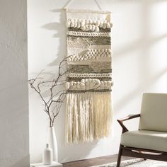 a room with a chair, rug and wall hanging