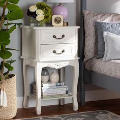 a bedroom with a bed, nightstand and plants on the side table next to it