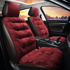 the interior of a car with red seats and black trims, in front of a scenic sunset