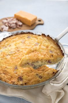 a casserole with meat and cheese in a glass dish on a blue table cloth