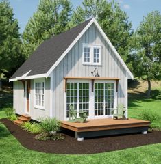 a small white house sitting on top of a lush green field