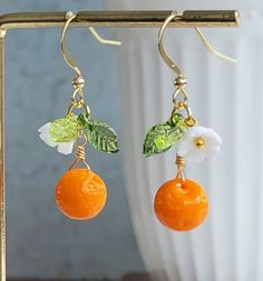 Lovely earrings feature 9 mm Czech glass orange bead, plastic leaves and white flowers.  On gold plated over brass ear wires and chain.  Delightful to wear! Earring length: 37 mm Please leave at the Personalization box of your necklace length if you purchase the necklace. Purchase over $40 enjoys free shipping! Coupon code 'freeshipping1'. Free Gift Wrapping on request - All items that are gift wrapped come in with a kraft box with raffia string and blank writing card.  Please leave a note if yo Nickel-free Orange Flower Earrings, Vintage Orange Flower Jewelry, Orange Vintage Flower Jewelry, Handmade Orange Dangle Flower Earrings, Orange Dangle Flower Earrings Gift, Orange Dangle Flower Earrings With Ear Wire, Orange Dangle Flower Earrings For Gift, Orange Drop Earrings For Gift, Vintage Orange Earrings For Gift