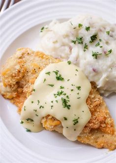 chicken with gravy and mashed potatoes on a white plate