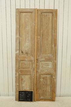 an old pair of doors with chalkboard on the bottom and bottom, in front of a white wall