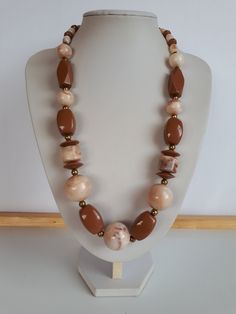 very beautiful piece! Vintage Retro chunky milk chocolate brown and swirl milk chocolate brown and biege lucite plastic beaded necklace with gold metal accent and different shapes and sizes of beads with lustrous surface with no seems and claps.  Circa 1975-1980. length: 24.5 inches; biggest ball beads: 7/8 inches diameter. good condition  To make this a smooth and pleasant transaction experience for everyone, all buyers need to read and understand the description, the terms of sale , the payment and the shipping indicated in this listing. Return not accepted - please ask before purchase. Thank you for watching our other items! A large collection of unique and unusual vintage items is listed. Plastic Necklace, Vintage Lucite, Creative Jewelry, Bead Jewellery, Plastic Beads, Necklace Vintage, Milk Chocolate, Metallic Accents, Chocolate Brown