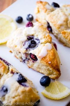 lemon blueberry scones on a cutting board with sliced lemons and blueberries