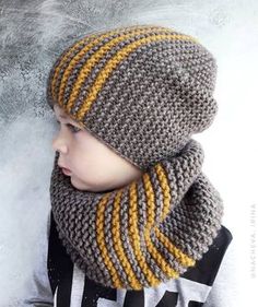 a little boy wearing a knitted hat and scarf in grey, yellow and white