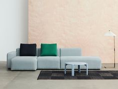 a living room with a couch, coffee table and lamp on the floor in front of a wood paneled wall