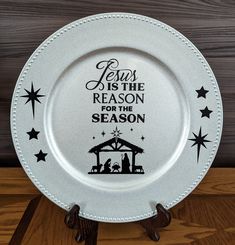 a white plate with the words jesus is the reason for the season on it sitting on a wooden table