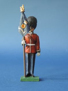 a toy soldier holding a flag on a blue background