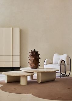 a living room filled with furniture next to a white chair and table on top of a rug