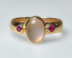 Stunning vintage, midcentury to 1970s...not entirely sure of its age. It does have an older hallmark. This is elegantly crafted ring with a comfortable low profile.  Featuring a clean luminescent 1.5ct Moonstone, flanked by two red Ruby's. Very pretty ring. 3.7g 14k solid yellow gold Hallmarked 4mm wide band Moonstone 1.5 ct Rubies 2 mm ea (.10ct) S 8 Us Resizable Excellent vintage condition Unique Ring Setting, Moonstone Gold Ring, Signet Rings Women Vintage, Vintage Ruby Ring, Rubin Ring, Ruby Ring Vintage, June Birthstone Ring, Pretty Ring, Signet Ring Men