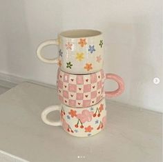 three mugs stacked on top of each other in the shape of hearts and flowers