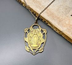 A beautiful genuine vintage Blessed Virgin Mary medal, French Mother Mary lucky charm, religious catholic holy charm, the reverse is engraved with initials from previous owner, lifetimes ago (see photo 2). Very nicely done, in good vintage condition, ideal for necklace, would make a nice gift for someone special! Floats from approx. 17 inch long vintage 925 silver cable type chain! Material: solid silver - gold plated vermeil Total weight: 5.7g Measures: approx. 35 x 22 mm (1.4 x 0.8 inch)  PLEASE LOOK AT THE PICTURES, THEY ARE PART OF THE DESCRIPTION AND ARE THE ACTUAL ITEM YOU WILL RECEIVE. ALL OUR ITEMS ARE IN WORN, VINTAGE CONDITION. Antique Miraculous Medal Pendant Jewelry, Antique Jewelry With Miraculous Medal For Collectors, Vintage Miraculous Medal Pendant Jewelry, Miraculous Medal Medallion For Commemoration, Vintage Jewelry With Miraculous Medal For Memorial, Vintage Crucifix Necklace With Miraculous Medal, Vintage Miraculous Medal Medallion Jewelry, Vintage Miraculous Medal Medallion, Mary Necklace Silver