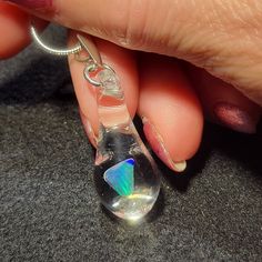 "My friend Marcy named this style of pendants. She said they look like Mermaid's tears. The hand blown teardrop dangle pendant is made by melting borosilicate glass tubing (pyrex) and blowing a bubble at the end of the tube in the flame. The pale blue Gilson opal polished nugget is then placed in the tube and is slowly melted so that the Gilson opal can be completely encased by the borosilicate glass and shaped into a teardrop. These opals flash a blue, green, yellow and even a little red color Hypoallergenic Glass Teardrop Jewelry, Silver Drop Glass Jewelry, Silver Glass Teardrop Jewelry, Silver Glass Drop Jewelry, Iridescent Teardrop Jewelry For Gift, Teardrop Pendant Jewelry With Natural Inclusions For Healing, Silver Teardrop Glass Necklaces, Iridescent Teardrop Necklace For Gifts, Clear Drop-shaped Glass Jewelry