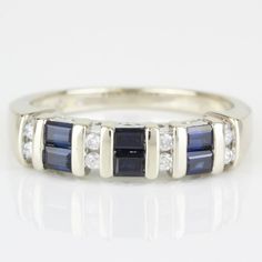 14k White Gold Sapphire Diamond & Anniversary Band Wedding Ring By Samuel Aaron This 14 Karat White Gold Ring Features 6 Baguette Sapphire Gemstones Measuring 3mm X 2mm Each, Complimented By 8 Round Diamonds Totaling .20 Carat. The Ring Is In Excellent Condition. This Ring Can Be Resized By Any Qualified Jeweler. Size: 7 Metal: 14 Karat White Gold Weight: 3.12dwt/ 4.84grams Gemstones: 6-Baguette Sapphires Diamonds: 8-Round .20 Carat Total I-2366 * Z-113 Formal Sapphire Half Eternity Rings, 14k White Gold Channel Set Jewelry, Formal Sapphire Multi-stone Ring In Cubic Zirconia, White Gold Sapphire Ring With Multi-stone Baguette Cut, Formal Multi-stone Sapphire Ring With Cubic Zirconia, Formal Sapphire Diamond Ring With Half Eternity Setting, Formal Sapphire Diamond Ring With Half Eternity, Modern Multi-stone Baguette Cut Jewelry, Classic Multi-stone Sapphire Ring With Baguette Cut